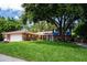 Charming brick home featuring a lush green lawn and mature trees offering plenty of shade at 237 Manatee Rd, Winter Haven, FL 33884