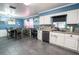 Open-concept kitchen boasts white cabinets, stone counters, and blue accent walls at 237 Manatee Rd, Winter Haven, FL 33884