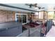 Inviting covered patio with brick accents, ceiling fans, dining area and adjacent hot tub for relaxing outdoor living at 237 Manatee Rd, Winter Haven, FL 33884
