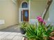 Close-up of the front door featuring decorative plants, tiled entryway and a half-moon window at 2538 Crown Ridge Cir, Kissimmee, FL 34744