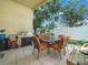 Covered patio with an outdoor dining table, grill, and a clean white fence for privacy at 2538 Crown Ridge Cir, Kissimmee, FL 34744