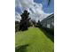 Spacious backyard with lush lawn, privacy hedges, and play structure in the distance at 25863 Crossings Bluff Ln, Sorrento, FL 32776