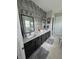 Elegant bathroom featuring dual sinks, a decorative wall tile accent, and modern fixtures at 25863 Crossings Bluff Ln, Sorrento, FL 32776
