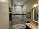 Modern bathroom with glass enclosed shower, textured gray tile, and decorative fixtures at 25863 Crossings Bluff Ln, Sorrento, FL 32776