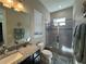 Stylish bathroom featuring a glass door shower, granite countertop, neutral paint, and natural lighting at 25863 Crossings Bluff Ln, Sorrento, FL 32776