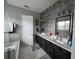 Modern bathroom featuring a dual vanity, decorative wall tile, and framed mirrors at 25863 Crossings Bluff Ln, Sorrento, FL 32776