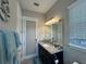 Bathroom featuring granite countertop vanity, decorative mirror, and natural light at 25863 Crossings Bluff Ln, Sorrento, FL 32776