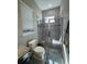 Bathroom featuring a tiled shower with glass door, toilet, and a window at 25863 Crossings Bluff Ln, Sorrento, FL 32776