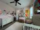 Pink themed bedroom with a crib, changing table, and shelving at 25863 Crossings Bluff Ln, Sorrento, FL 32776
