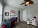 Bright bedroom featuring a desk, shelves with toys, and an overhead fan at 25863 Crossings Bluff Ln, Sorrento, FL 32776