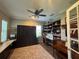 Bedroom with a ceiling fan, built-in shelving, desk, wood floors and an area rug at 25863 Crossings Bluff Ln, Sorrento, FL 32776