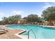 Resort-style community pool area with lounge chairs, umbrellas, and lush landscaping at Red Tail at 25863 Crossings Bluff Ln, Sorrento, FL 32776