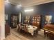 Stylish dining room features dark accent wall, wood floors, and piano at 25863 Crossings Bluff Ln, Sorrento, FL 32776