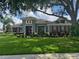 Well-manicured front yard and mature trees adorn this lovely single-Gathering home with red shutters at 25863 Crossings Bluff Ln, Sorrento, FL 32776
