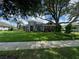 Landscaped front lawn with a view of the home's facade and a paved sidewalk at 25863 Crossings Bluff Ln, Sorrento, FL 32776