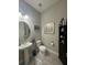 Stylish half bath featuring a modern vanity, round mirror, and decorative nautical accents at 25863 Crossings Bluff Ln, Sorrento, FL 32776