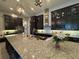 Spacious kitchen features a large granite island and dark wood cabinets providing ample space and modern style at 25863 Crossings Bluff Ln, Sorrento, FL 32776