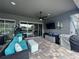 Covered patio with comfortable seating, ceiling fan, and outdoor kitchen prep area at 25863 Crossings Bluff Ln, Sorrento, FL 32776