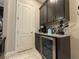 Convenient wet bar area complete with wine fridge, cabinets, and granite counters at 25863 Crossings Bluff Ln, Sorrento, FL 32776