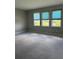 Bedroom with plush carpeting, neutral paint, and three sunny windows at 2609 Village Lakes Blvd, Lakeland, FL 33805
