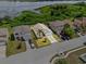 An aerial view of a single-Gathering home near a lake with a well-manicured lawn and mature landscaping at 2740 Rochelle Dr, Winter Haven, FL 33881