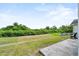 Spacious backyard featuring lush lawn, mature trees, and a concrete patio at 2740 Rochelle Dr, Winter Haven, FL 33881