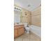 Cozy bathroom features a shower-tub combo, wood vanity, and tile floors at 2740 Rochelle Dr, Winter Haven, FL 33881