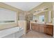 Bathroom featuring a soaking tub, glass-enclosed shower, double vanity, and tiled flooring at 2740 Rochelle Dr, Winter Haven, FL 33881
