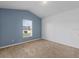 Comfortable bedroom with neutral carpeting, large window, and a contrasting blue accent wall at 2740 Rochelle Dr, Winter Haven, FL 33881
