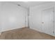 Bright bedroom with neutral carpeting, white walls, and access to another room through a white door at 2740 Rochelle Dr, Winter Haven, FL 33881