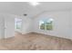 Well-lit bedroom with two windows, neutral carpeting, and a white door leading to another room at 2740 Rochelle Dr, Winter Haven, FL 33881