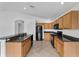 Modern kitchen with wood cabinets, tiled floor, and breakfast bar provides ample space for cooking and entertaining at 2740 Rochelle Dr, Winter Haven, FL 33881