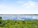 Picturesque lake view with blue water, green vegetation, and cloud reflections at 2740 Rochelle Dr, Winter Haven, FL 33881