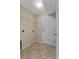 Tiled laundry room equipped with washer hookups, wire shelving, and exterior access at 2740 Rochelle Dr, Winter Haven, FL 33881