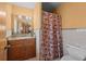 Functional bathroom features a wood vanity, tiled shower with curtain, and a toilet at 2800 Sunset Nw Dr, Winter Haven, FL 33881