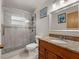 Bathroom featuring granite countertops, white tile shower, and stylish vanity at 2800 Sunset Nw Dr, Winter Haven, FL 33881