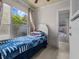 Cozy bedroom features large windows, tile flooring and a bright blue and white blanket at 2800 Sunset Nw Dr, Winter Haven, FL 33881