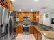 Open kitchen layout with stainless steel refrigerator and range at 2800 Sunset Nw Dr, Winter Haven, FL 33881
