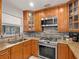 Kitchen area with stainless steel appliances, wooden cabinets, and tile backsplash at 2800 Sunset Nw Dr, Winter Haven, FL 33881