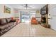 Living room boasts tile floors, stone fireplace, ceiling fan, and sliding glass doors to the patio at 2800 Sunset Nw Dr, Winter Haven, FL 33881
