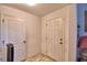 Hallway featuring neutral walls, marble flooring, and two white paneled doors at 286 Cove At Eagle Lake Cir, Eagle Lake, FL 33839