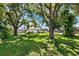 Secluded backyard view framed by mature trees offers a peaceful retreat and a glimpse of the home's exterior at 2861 Pond View Dr, Haines City, FL 33844