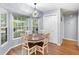 The dining room features modern lighting, a round table, and large windows overlooking the backyard at 2861 Pond View Dr, Haines City, FL 33844