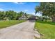 View of the home featuring a well-maintained lawn, a long driveway, and an attached garage at 2861 Pond View Dr, Haines City, FL 33844