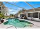 Backyard view of the sparkling pool with screened enclosure, lush landscaping, and outdoor seating at 2861 Pond View Dr, Haines City, FL 33844