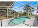 Backyard view featuring an in-ground pool with a screened enclosure and lush landscape at 2861 Pond View Dr, Haines City, FL 33844