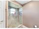 Tiled glass shower featuring shelving, and mounted shower head inside a neutral toned bathroom at 2861 Pond View Dr, Haines City, FL 33844