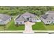 Aerial view of gray home featuring solar panels, manicured lawn, fenced yard, and mature landscaping at 308 Kissengen Park Dr, Bartow, FL 33830