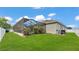 A spacious backyard featuring a screened-in pool enclosure with lush landscaping and a white fence at 308 Kissengen Park Dr, Bartow, FL 33830
