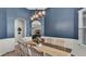 Charming dining room with blue walls, wainscoting, and a rustic wood table at 308 Kissengen Park Dr, Bartow, FL 33830